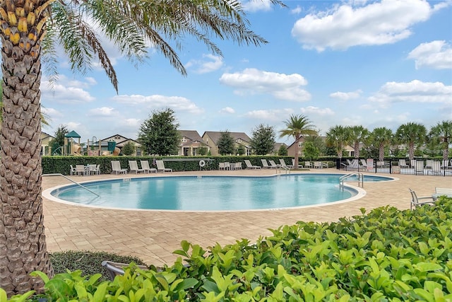 pool with a patio and fence