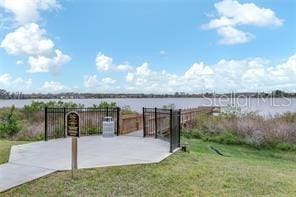 view of patio featuring fence and a water view