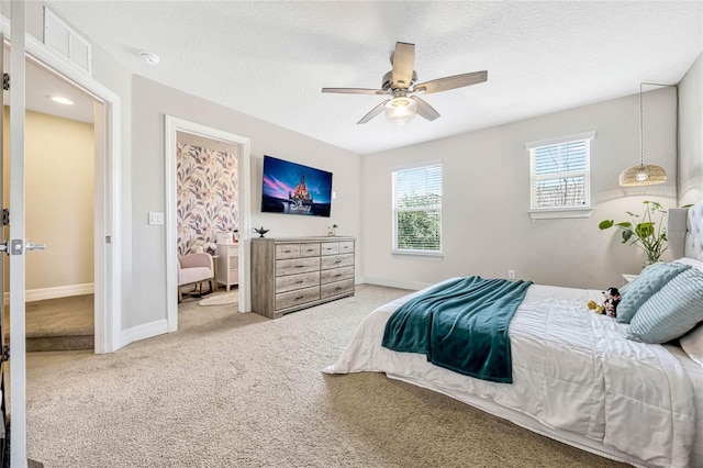 carpeted bedroom with ceiling fan and a textured ceiling