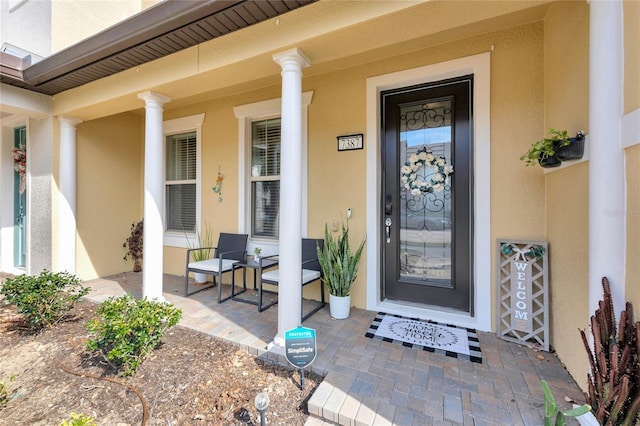 property entrance featuring stucco siding and a porch