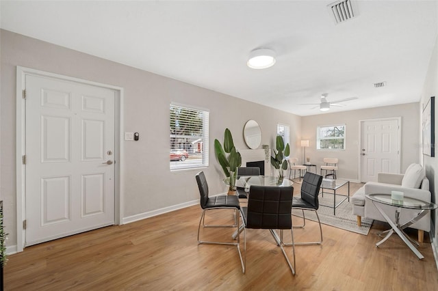 dining space with ceiling fan and light hardwood / wood-style flooring