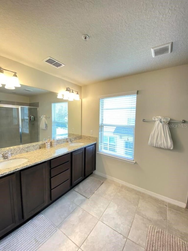 bathroom with vanity, tile patterned floors, a textured ceiling, and walk in shower