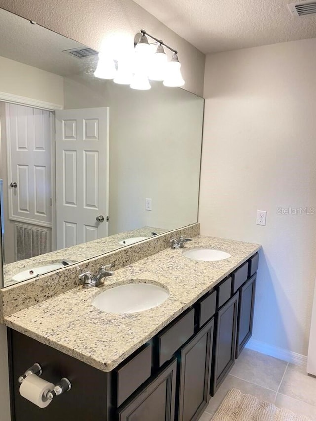 bathroom featuring vanity, tile patterned flooring, and a textured ceiling