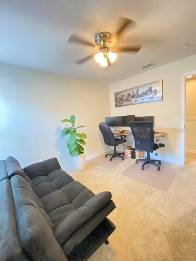 carpeted home office featuring ceiling fan