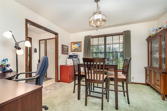 carpeted dining area featuring a textured ceiling