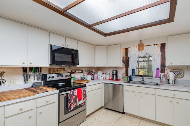 kitchen featuring white cabinetry, sink, stainless steel appliances, and light tile patterned flooring