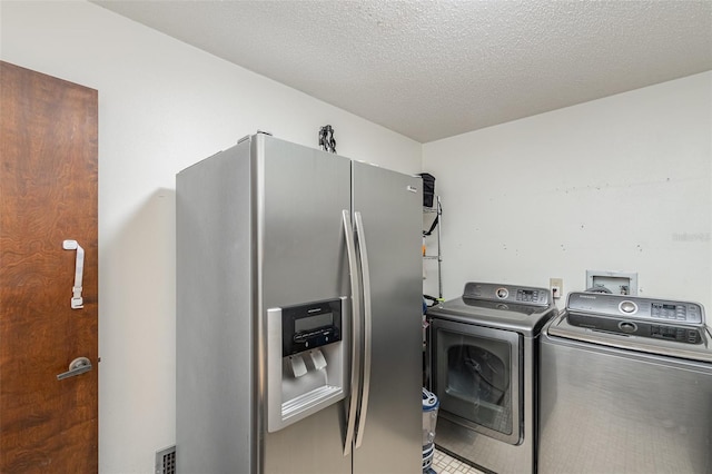 washroom with washer and dryer and a textured ceiling