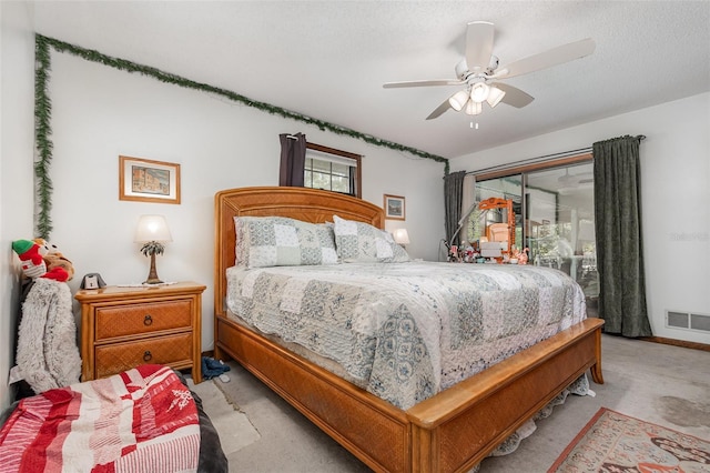 carpeted bedroom with ceiling fan, access to outside, and a textured ceiling