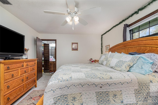 bedroom with ceiling fan and a textured ceiling