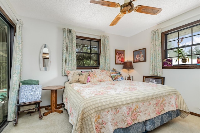 carpeted bedroom with ceiling fan and a textured ceiling