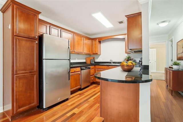 kitchen with crown molding, appliances with stainless steel finishes, sink, and light hardwood / wood-style floors