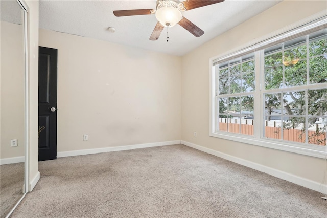 unfurnished room with light colored carpet and ceiling fan