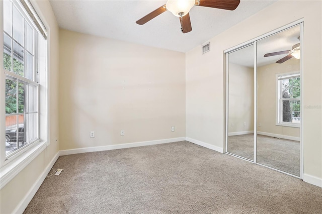 unfurnished bedroom featuring carpet, ceiling fan, and a closet