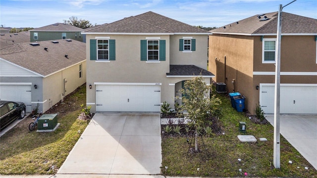 view of front of house with a garage and central air condition unit