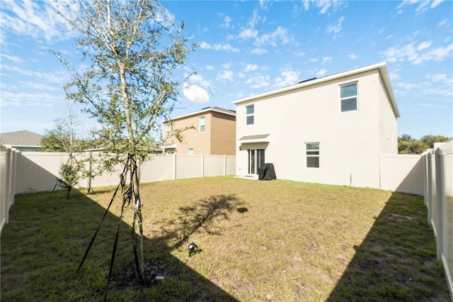 rear view of property featuring a lawn