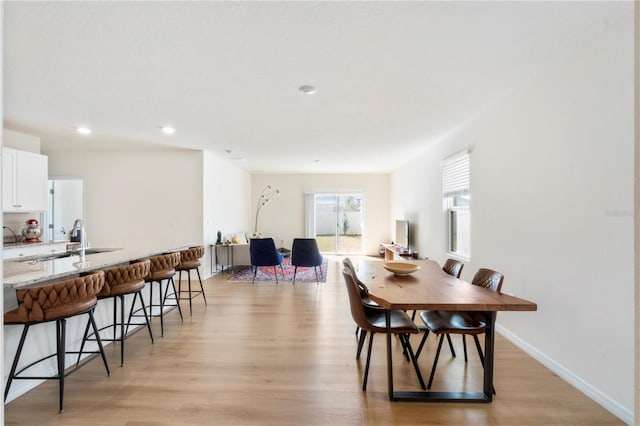 dining area with sink and light hardwood / wood-style floors