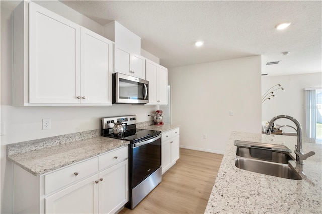 kitchen featuring white cabinetry, stainless steel appliances, and sink