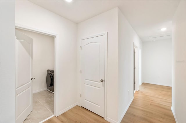 corridor with washer / dryer and light wood-type flooring