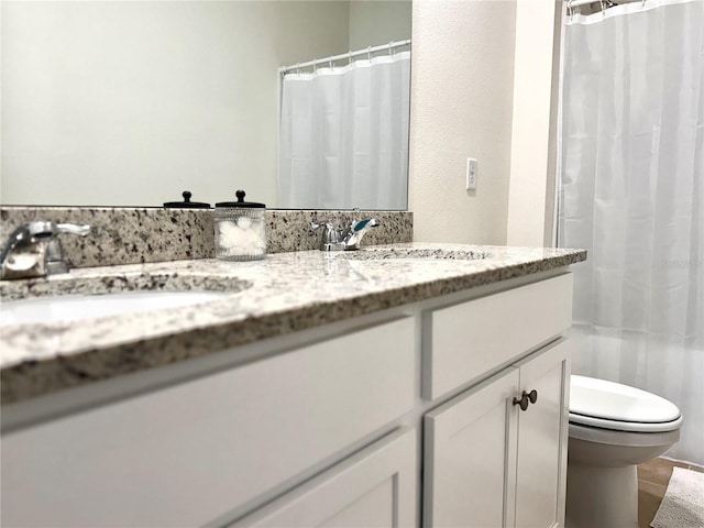 bathroom featuring toilet, vanity, and a shower with shower curtain