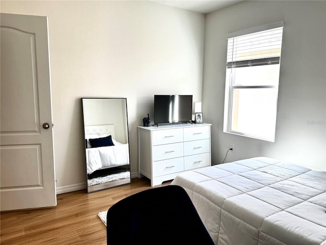 bedroom with multiple windows and light hardwood / wood-style flooring