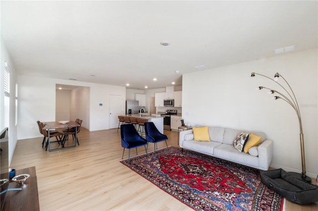 living room with visible vents, light wood finished floors, and recessed lighting