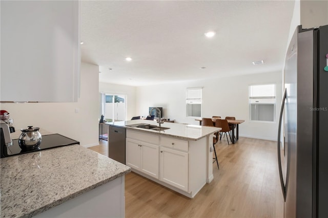 kitchen with white cabinetry, a sink, stainless steel appliances, and light wood-type flooring
