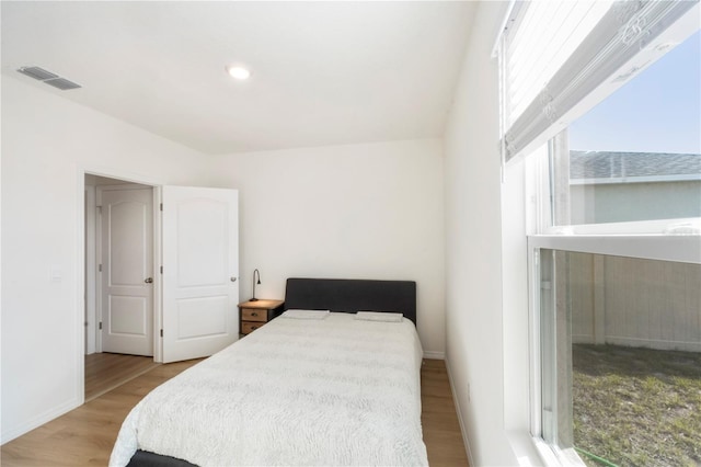 bedroom with baseboards, visible vents, wood finished floors, and recessed lighting