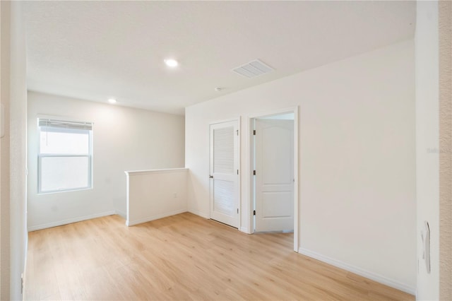 empty room with baseboards, visible vents, recessed lighting, and light wood-type flooring