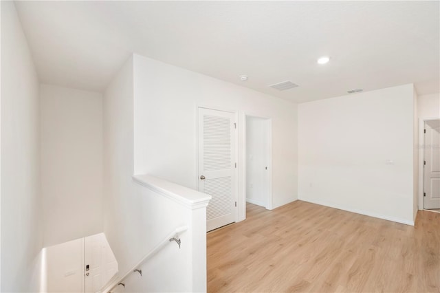 unfurnished room with baseboards, light wood-type flooring, and visible vents