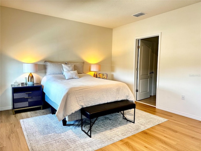bedroom featuring light wood finished floors, baseboards, and visible vents
