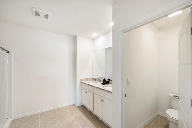 bathroom with visible vents, baseboards, toilet, vanity, and tile patterned flooring