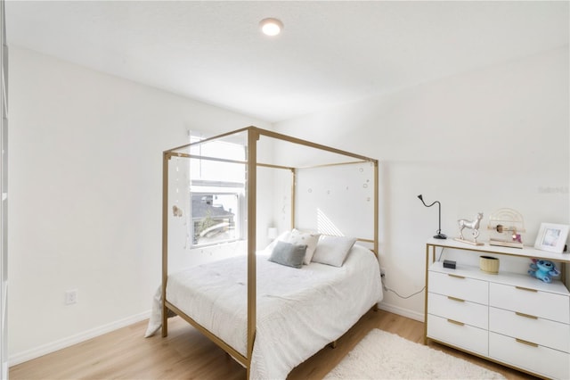 bedroom with baseboards and light wood-type flooring