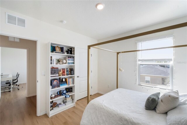 bedroom with light wood finished floors and visible vents