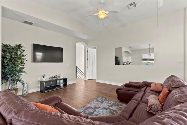 living room with ceiling fan, dark hardwood / wood-style floors, and vaulted ceiling