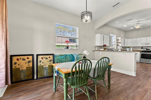 dining space with dark hardwood / wood-style floors and ceiling fan