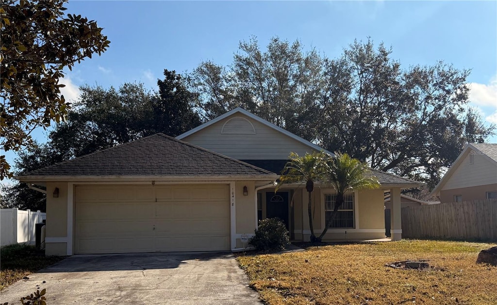 single story home with a garage and a front lawn