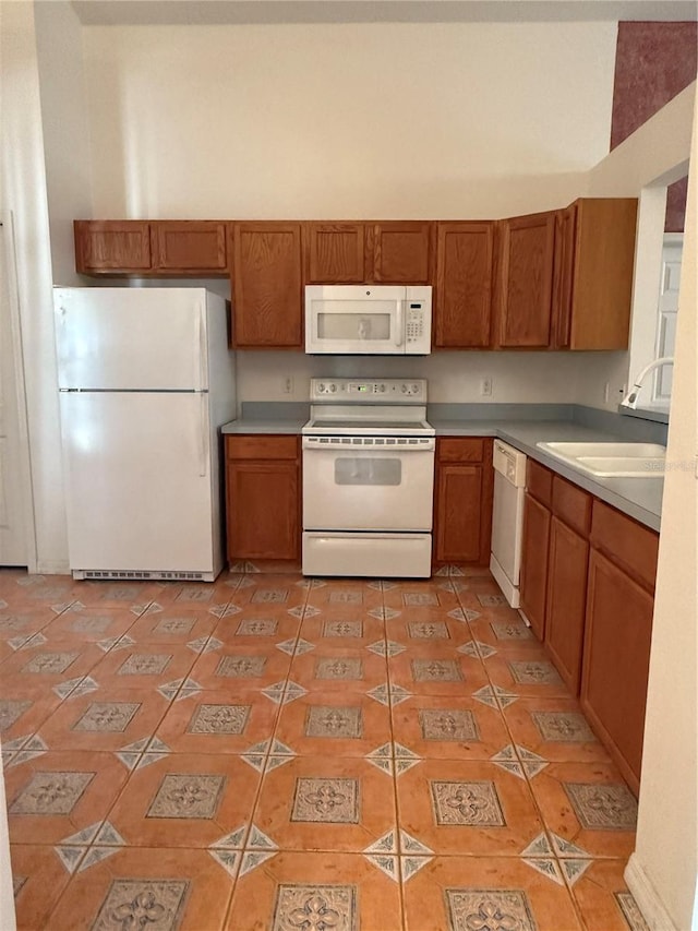 kitchen featuring sink, white appliances, and light tile patterned flooring