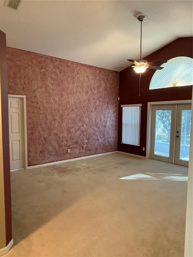 carpeted spare room featuring french doors, ceiling fan, and lofted ceiling