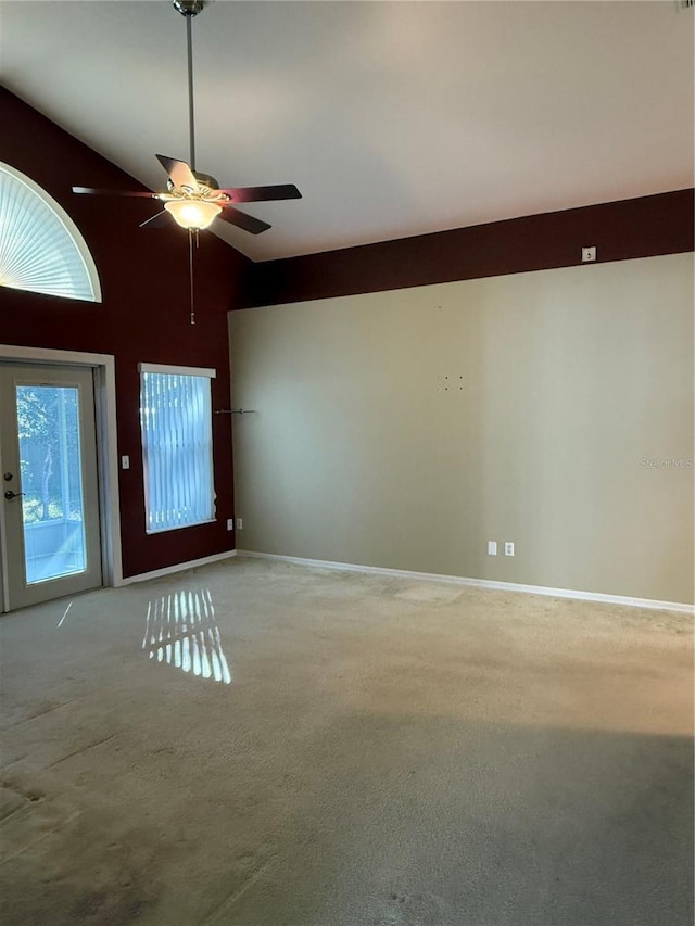 spare room featuring light carpet, high vaulted ceiling, and ceiling fan