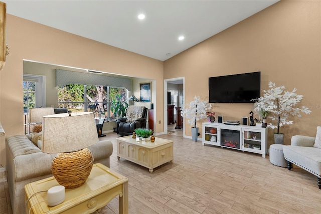 living room featuring vaulted ceiling and light wood-type flooring