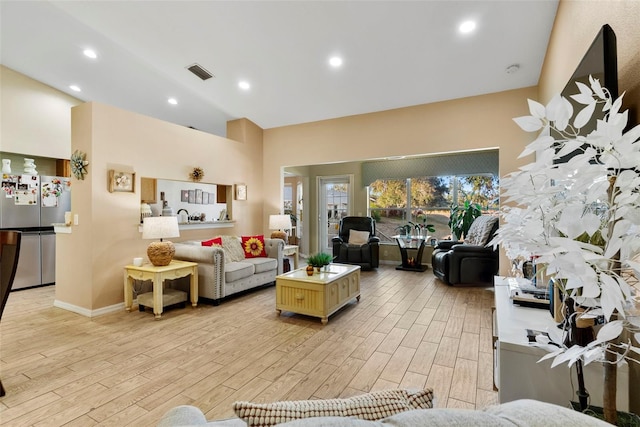 living room with high vaulted ceiling and light wood-type flooring