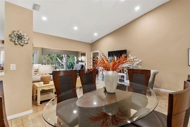 dining area featuring lofted ceiling and light hardwood / wood-style flooring