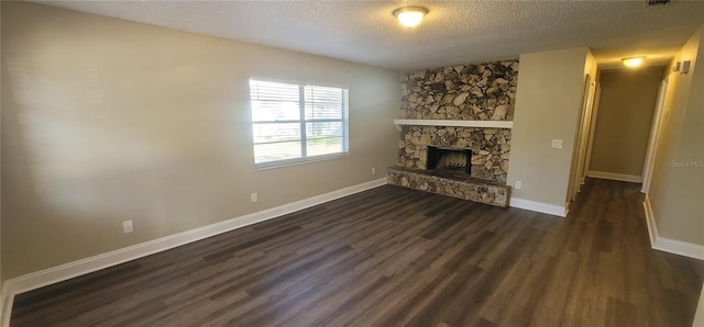 unfurnished living room featuring dark hardwood / wood-style floors, a fireplace, and a textured ceiling