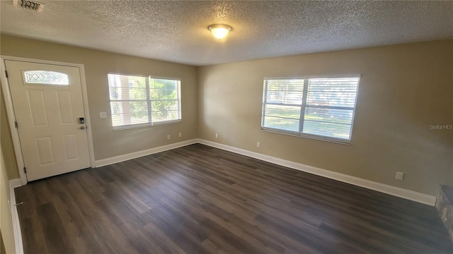 foyer with dark wood-type flooring and a textured ceiling