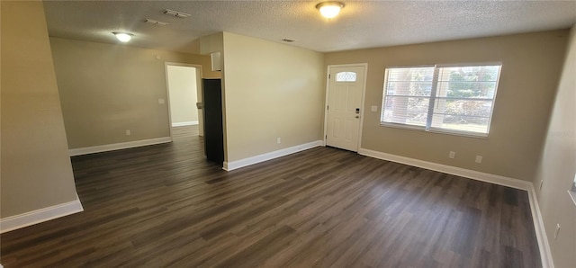 interior space featuring dark wood-type flooring and a textured ceiling