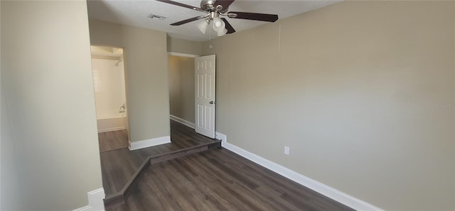 spare room with ceiling fan, dark hardwood / wood-style floors, and a textured ceiling