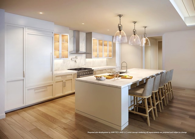10601 Autumn Mist Ln Unit 302, Golden Oak, FL 32836 - kitchen with stainless steel stove, a kitchen island with sink, wall chimney exhaust hood, light wood finished floors, and a sink
