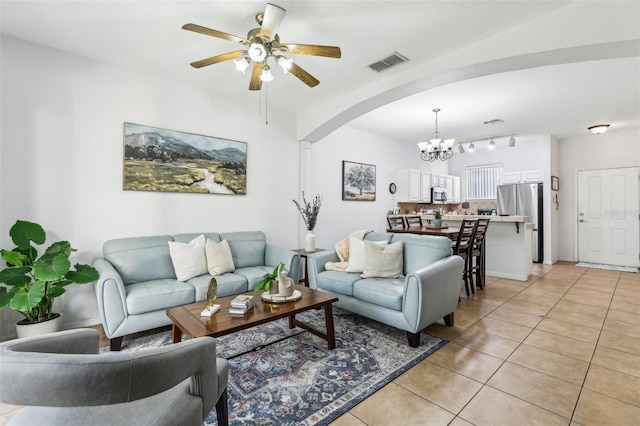 living room with light tile patterned floors and ceiling fan with notable chandelier