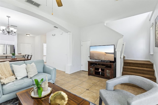 tiled living room featuring ceiling fan with notable chandelier