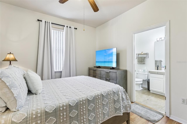 bedroom with ceiling fan, ensuite bathroom, light hardwood / wood-style floors, and multiple windows